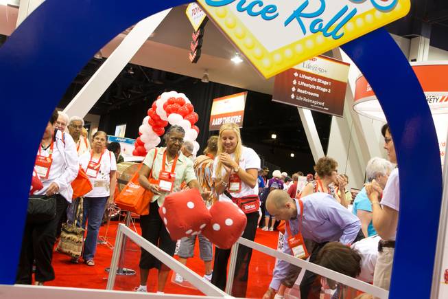Betty Gibson of Chicago rolls a pair of oversized dice at the AARP Driver Safety booth during the 2013 AARP Convention on Thursday, May 30, 2013.